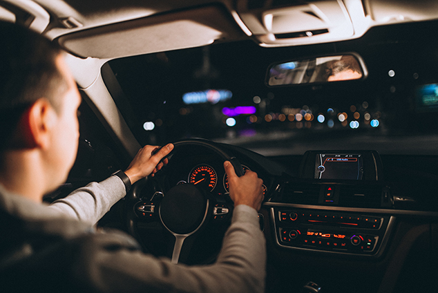 young-man-driving-his-car-night-time